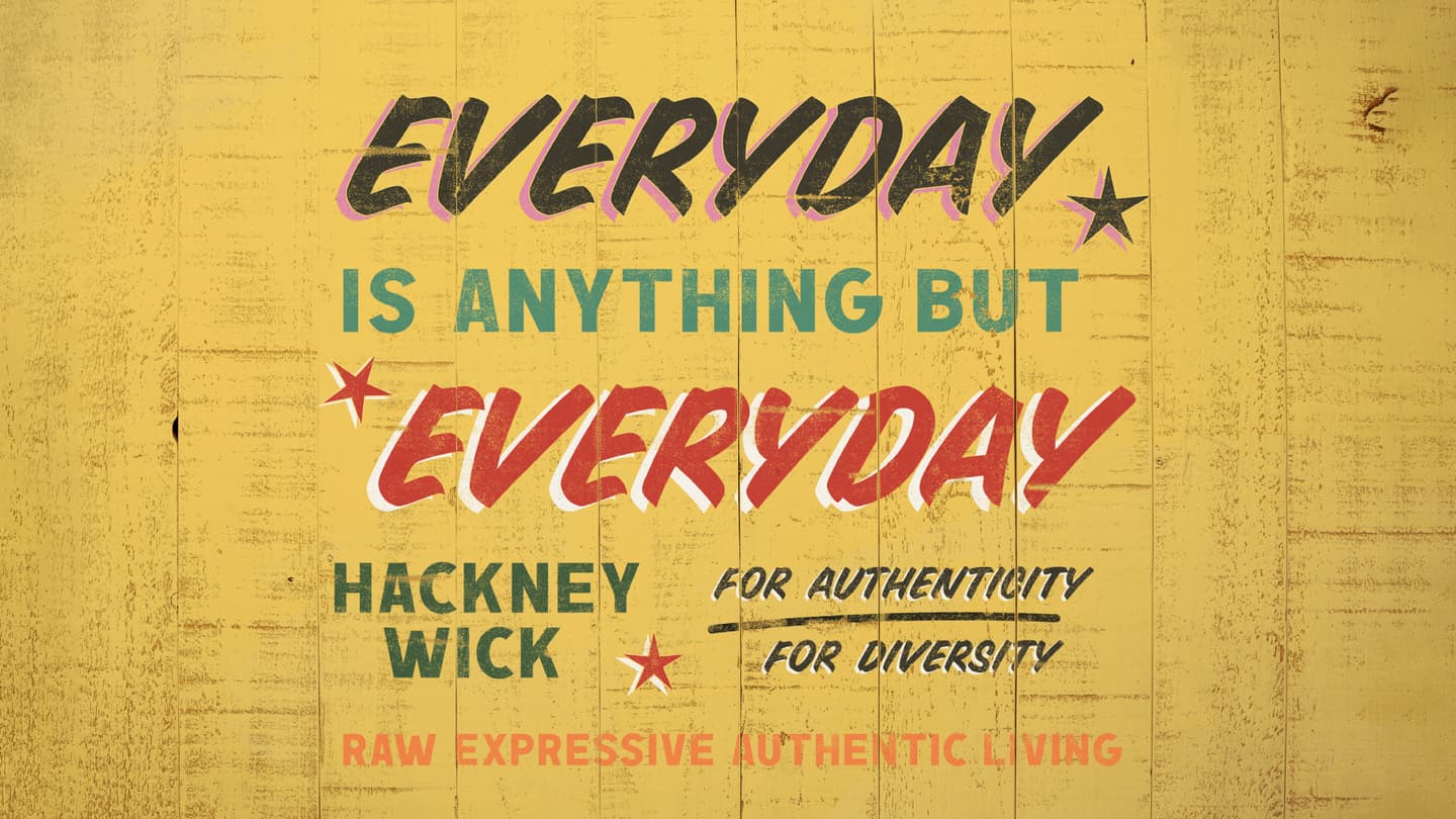 Text on a yellow wooden wall reads: Every day is anything but everyday. Hackney Wick for authenticity, for diversity. Raw expressive authentic living.