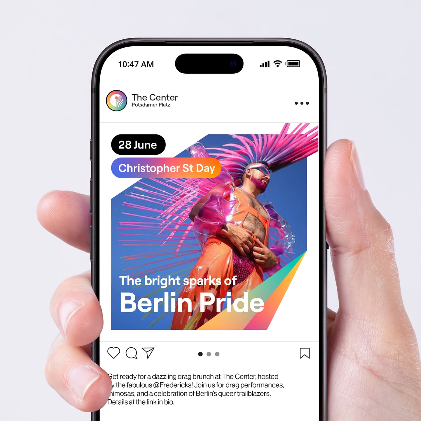 A hand holds a mobile displaying a social media post for Berlin Pride on 28 June, featuring a colourful performer in reflective sunglasses and an orange outfit under a bright sky.