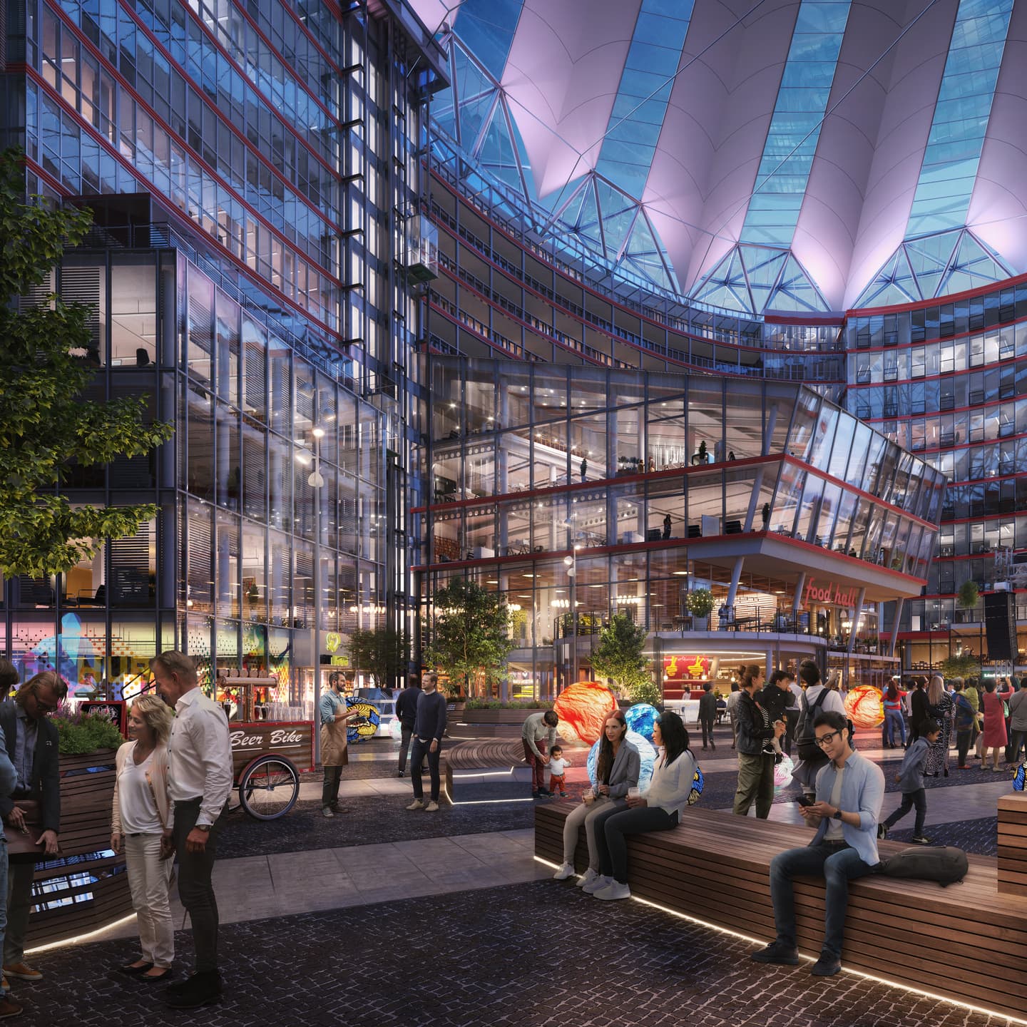 People gather in a modern, illuminated urban plaza with glass buildings, shops, food stalls, and a curved translucent roof overhead at night. Some sit on benches; others walk or talk.