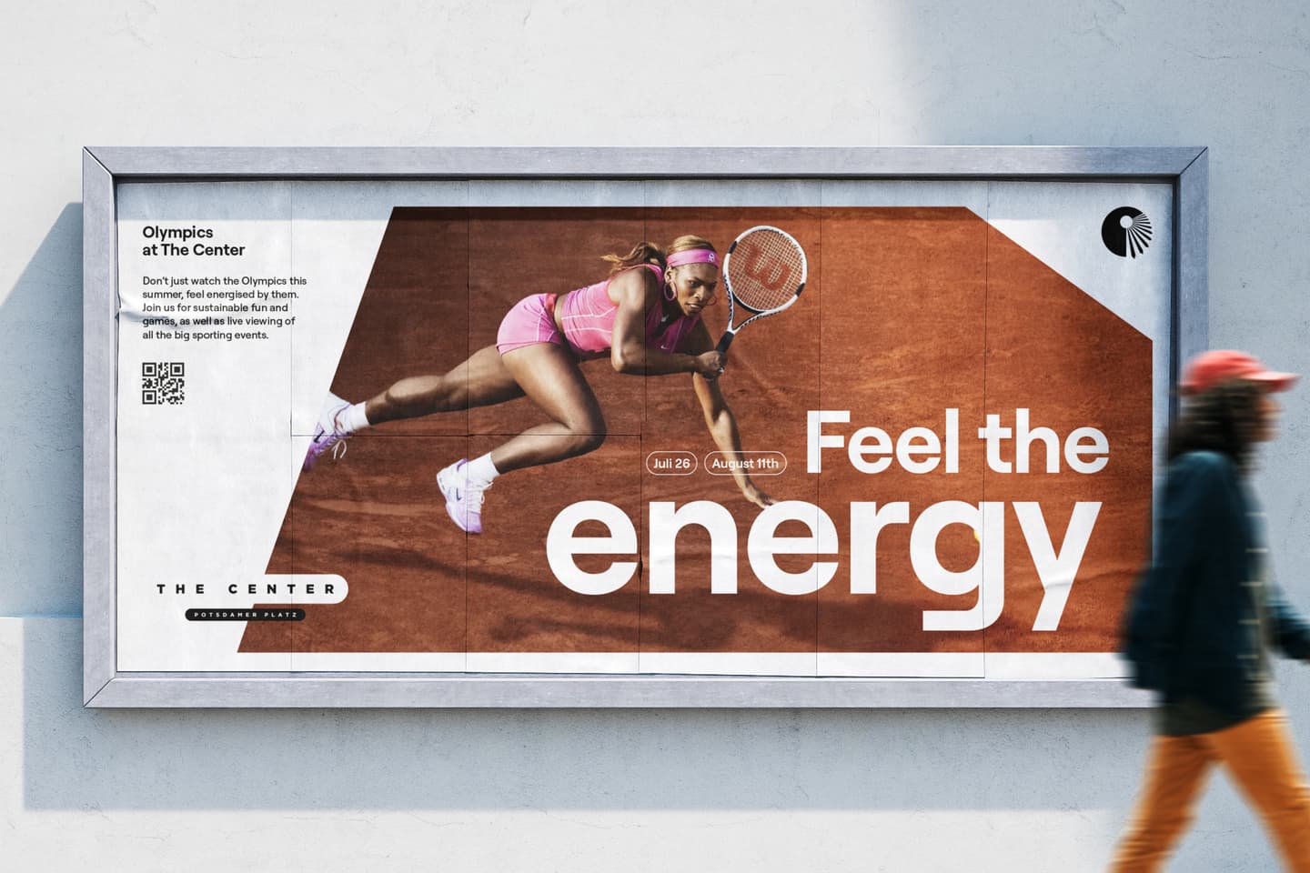 A hoarding shows a tennis player in action on a clay court with the text Feel the energy and event details; a person in a teal coat walks past.