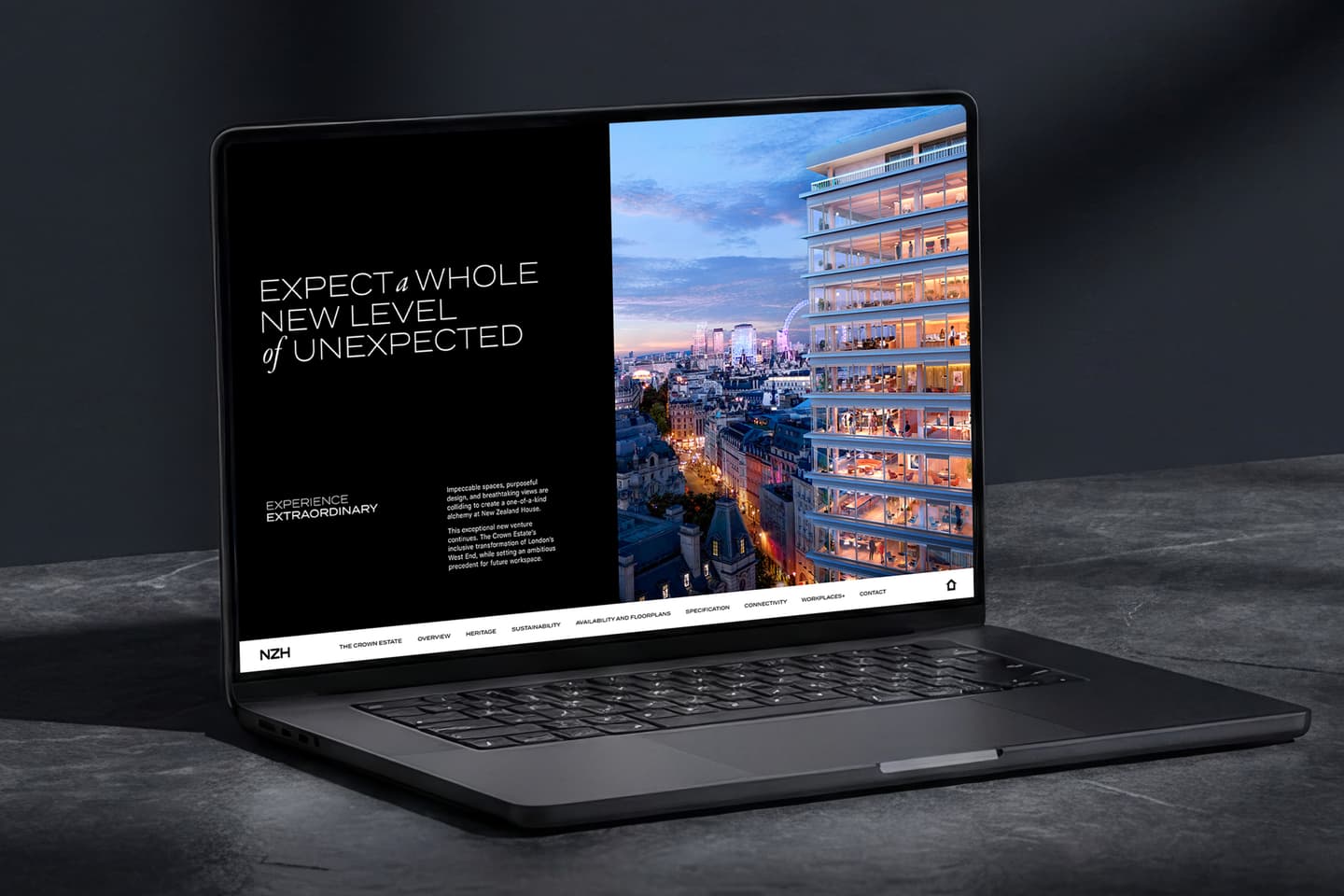 A black laptop displays a website featuring a cityscape at sunset and modern high-rise flats, with text reading Expect a whole new level of unexpected..